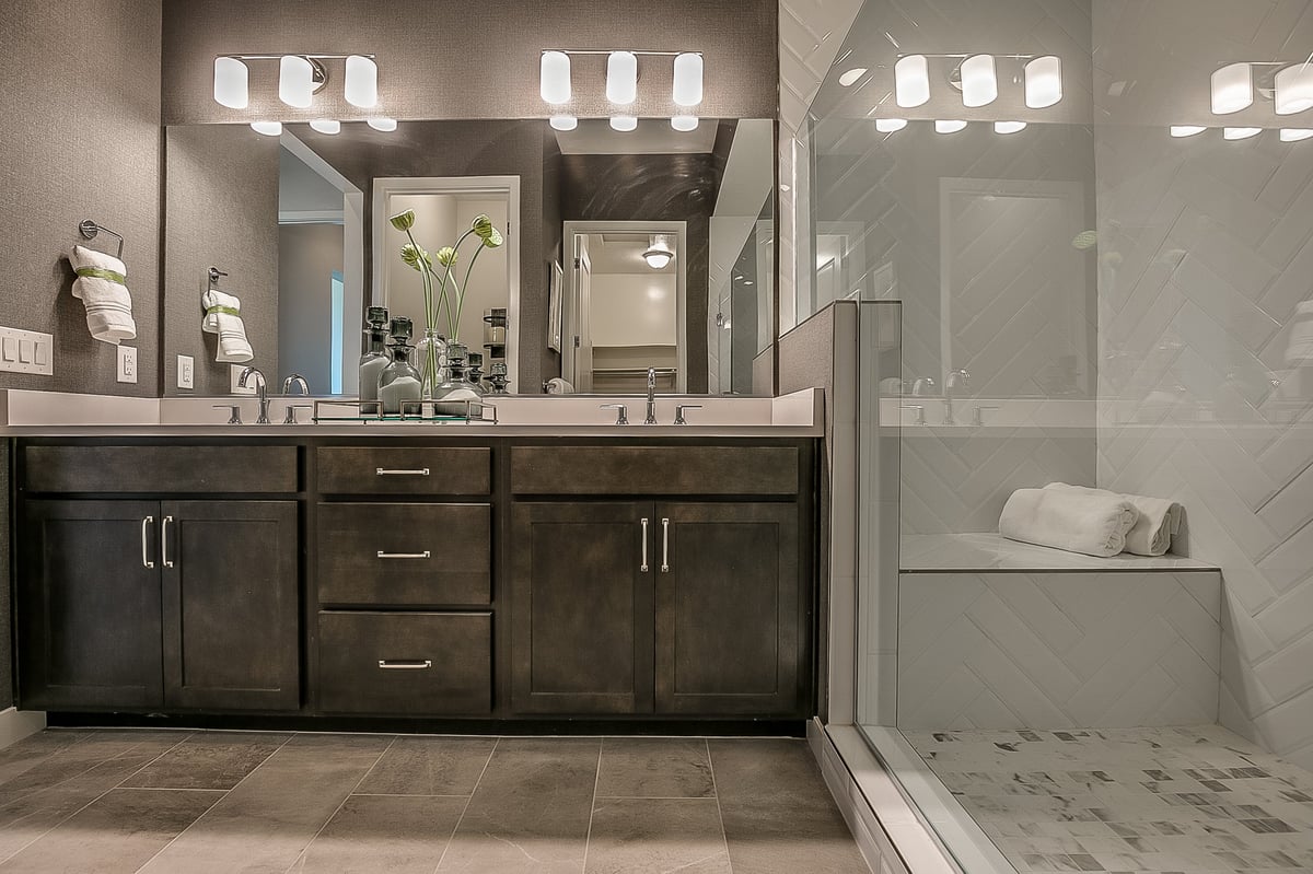 Large bright shower with tile and a bench