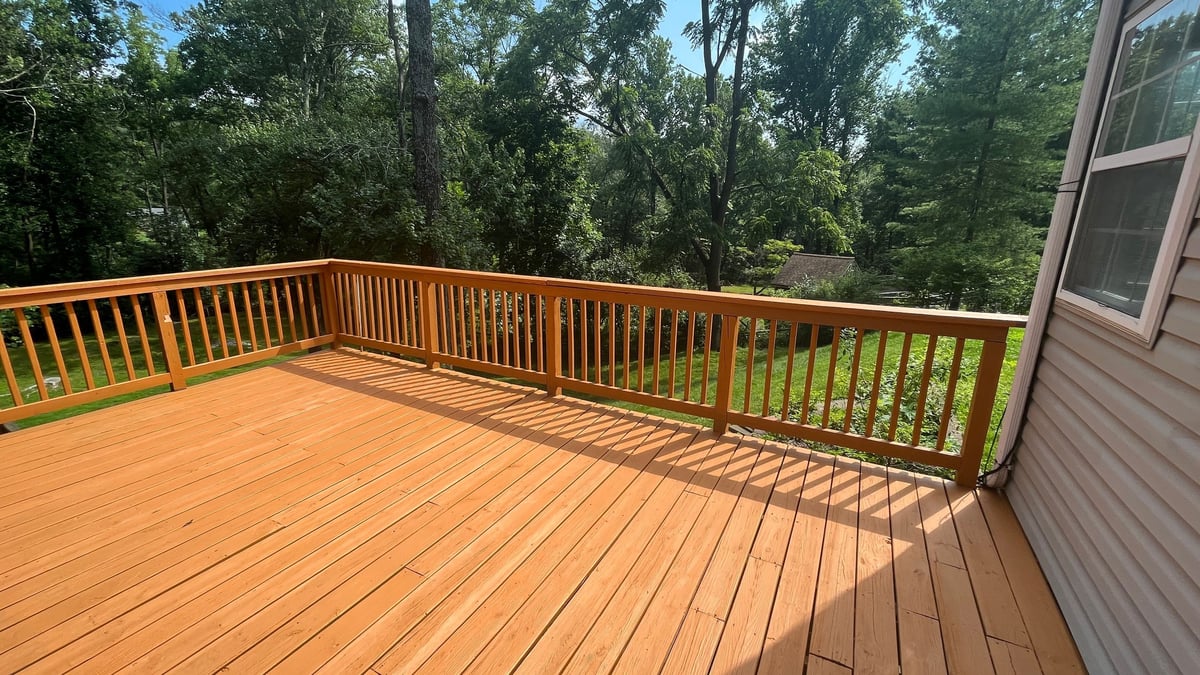 Wooden deck with sliding glass doors overlooking green space